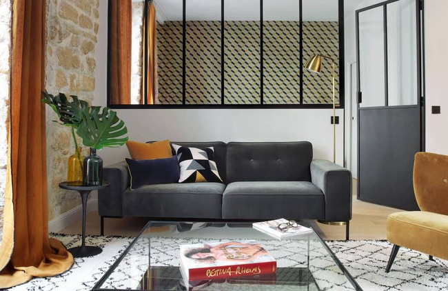 Phòng khách được bài trí sofa chữ I đơn giản với bàn nước khung thép, mặt thủy tinh đem đến cảm giác nhẹ nhàng, gọn gàng Nhà đẹp