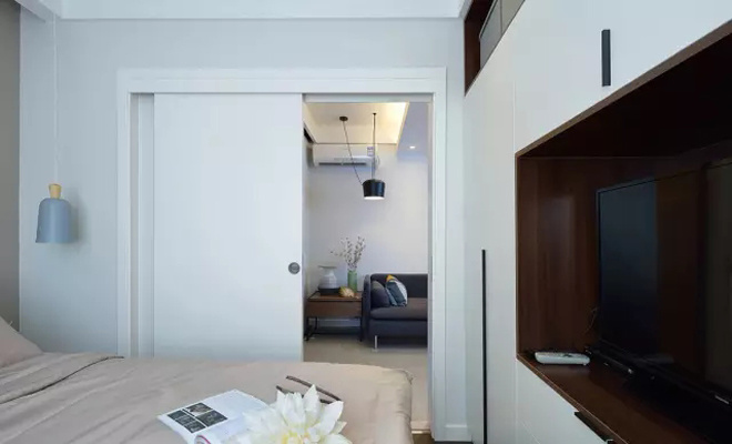 Phòng ngủ bé chỉ có tông màu trắng - be với hệ tủ kệ giống như mảng tường lớn Phòng ngủ