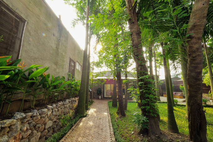 Bờ tường được ốp đá, lối đi quanh nhà lát gạch mộc, xung quanh trồng những cây thiên điểu gợi nhớ hình ảnh của núi rừng Kiến trúc đẹp