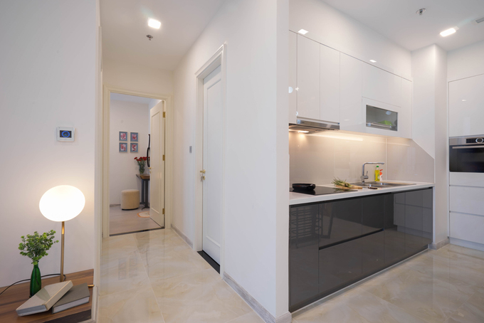 Khu bếp hình chữ L được thiết kế phẳng như những mảng tường, gọn gàng với hai màu trắng đen căn hộ đen trắng