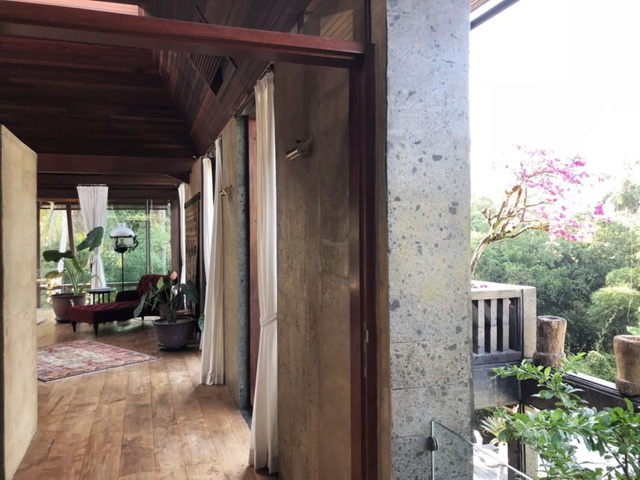 Không gian nội thất mềm mại, lãng mạn nhờ sự kết hợp của rèm cửa rủ màu sáng và những mảng tường đá sẫm màu. không gian nội thất