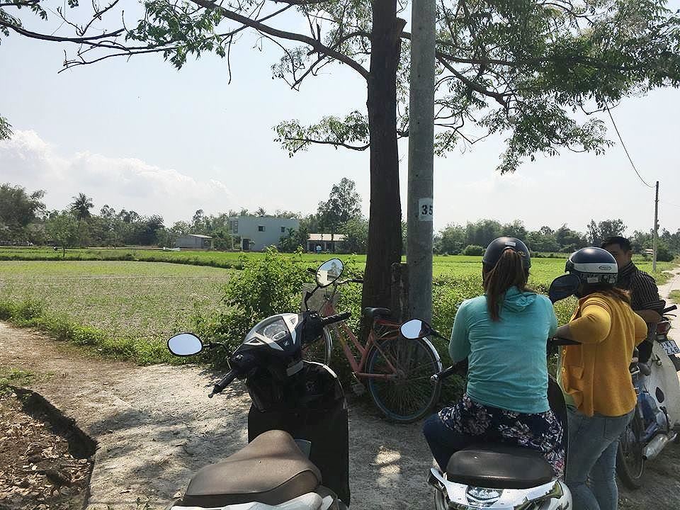 Một nhóm cò đất đứng trao đổi mua bán bên một thửa đất cò đất