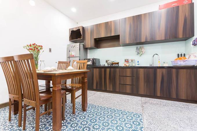 Cuối tầng trệt là bếp và phòng ăn bố trí cạnh giếng trời. Thay vì dùng thảm, kiến trúc sư dùng gạch bông phân vùng không gian, với họa tiết tương đồng khu vực sinh hoạt chung tạo sự thống nhất trong trang trí. phòng bếp đẹp