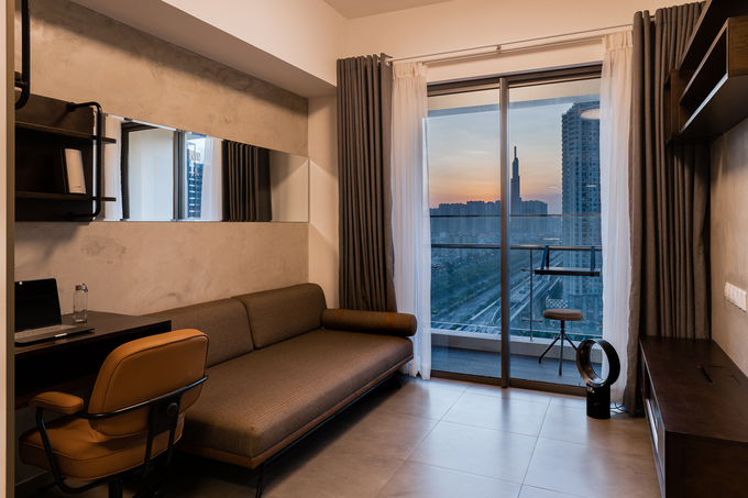 Phòng khách gồm một ghế sofa kiêm giường ngủ, kệ ti vi kiêm chức năng bàn làm việc hoặc bàn tiếp khách nội thất đa năng