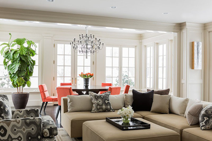 Phía sau sofa phòng khách là bộ bàn ăn có những chiếc ghế màu hồng san hô ghế ăn màu hồng san hô