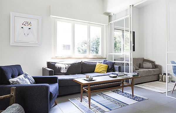Sofa màu xanh hải quân giúp giảm bớt cường độ sáng cho phòng khách khi nắng gắt và cân bằng ánh sáng cho không gian trắng. sofa xanh hải quân