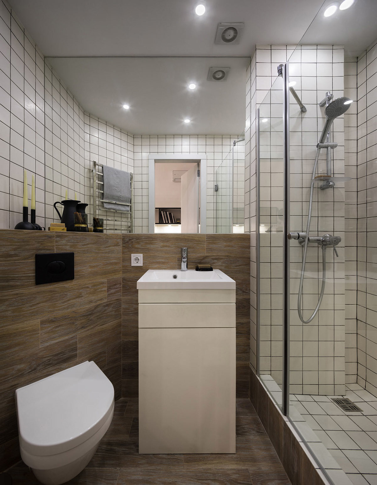 Tường và sàn phòng tắm đều được ốp gỗ, bồn cầu treo tường tiết kiệm diện tích. Bên dưới bồn rửa là kệ lưu trữ màu trắng giúp cất gọn các đồ dùng, đồ trang điểm. thiết kế phòng tắm nhỏ