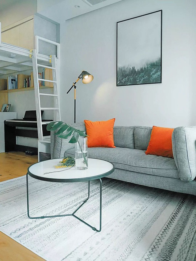Phòng khách với tâm điểm là bộ sofa nhấn nhá thêm gối dựa màu cam bắt mắt, bàn trà đơn giản, tinh tế nội thất cho căn hộ nhỏ