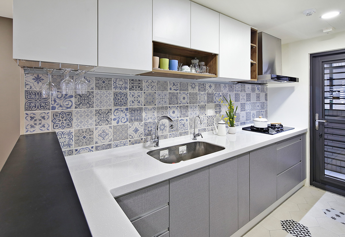 Một mảng tường khu bếp được ốp bằng gạch hoa, nhắc lại chi tiết trang trí ở sảnh vào căn hộ tường bếp ốp gạch hoa