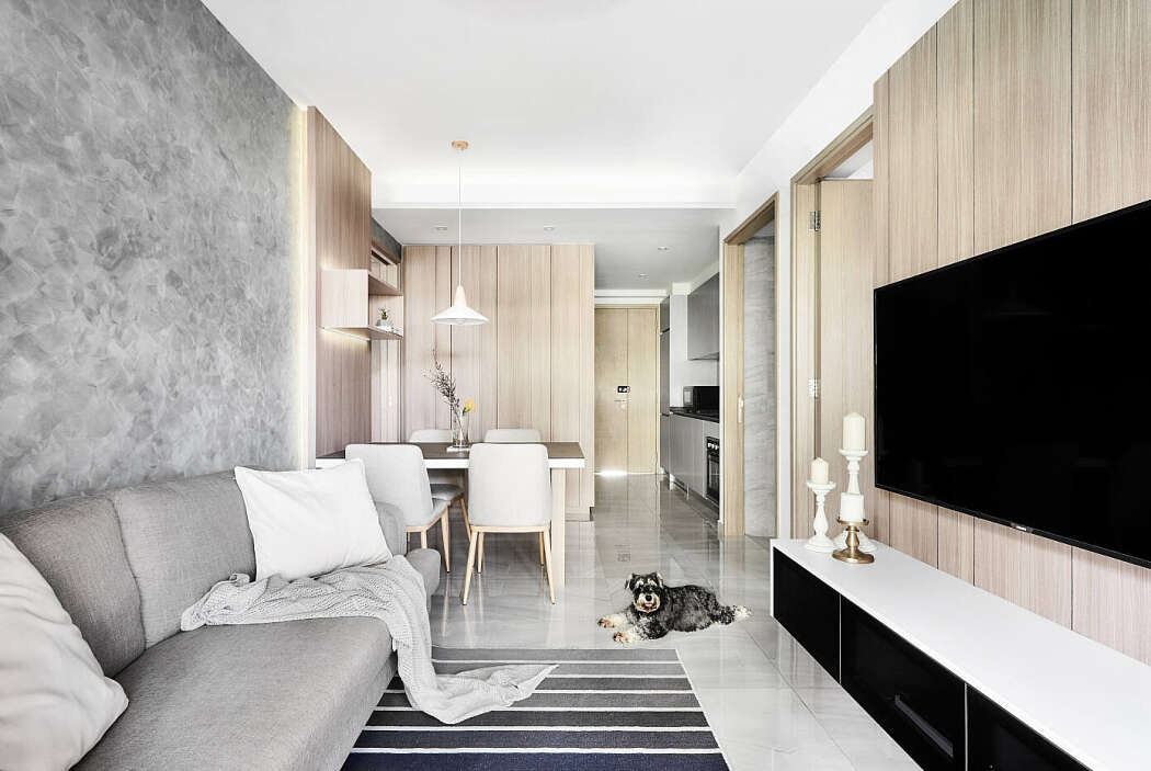 Phòng khách nhỏ bố trí cạnh bàn ăn Phòng khách nhỏ, sofa đơn, thảm trải sàn sọc đèn, kệ tivi, chú chó nằm trên sàn