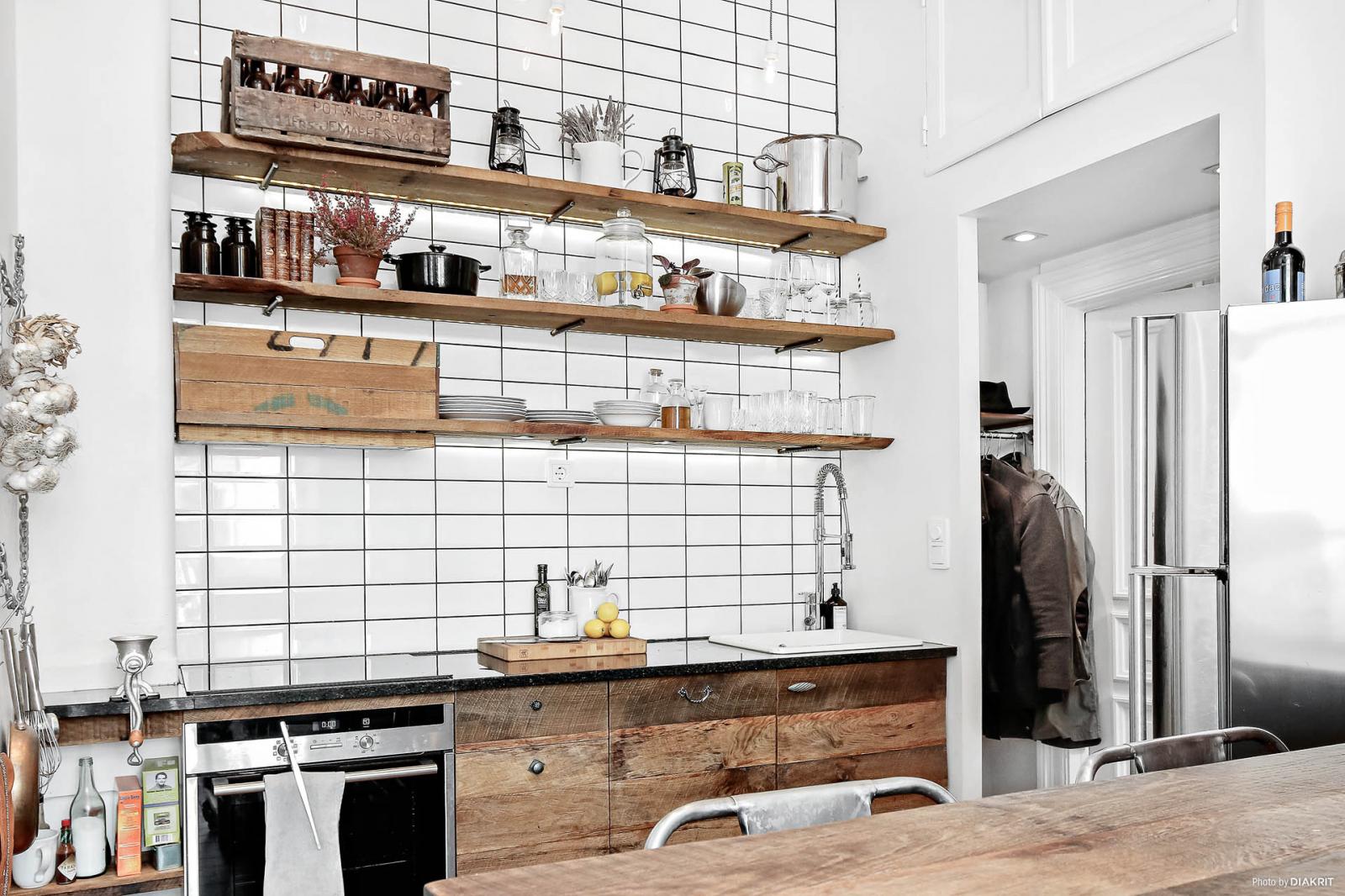 Bếp nhỏ lưu trữ kiểu Scandi. Kệ gỗ mở đặt nhiều đồ đạc phía trên bếp.